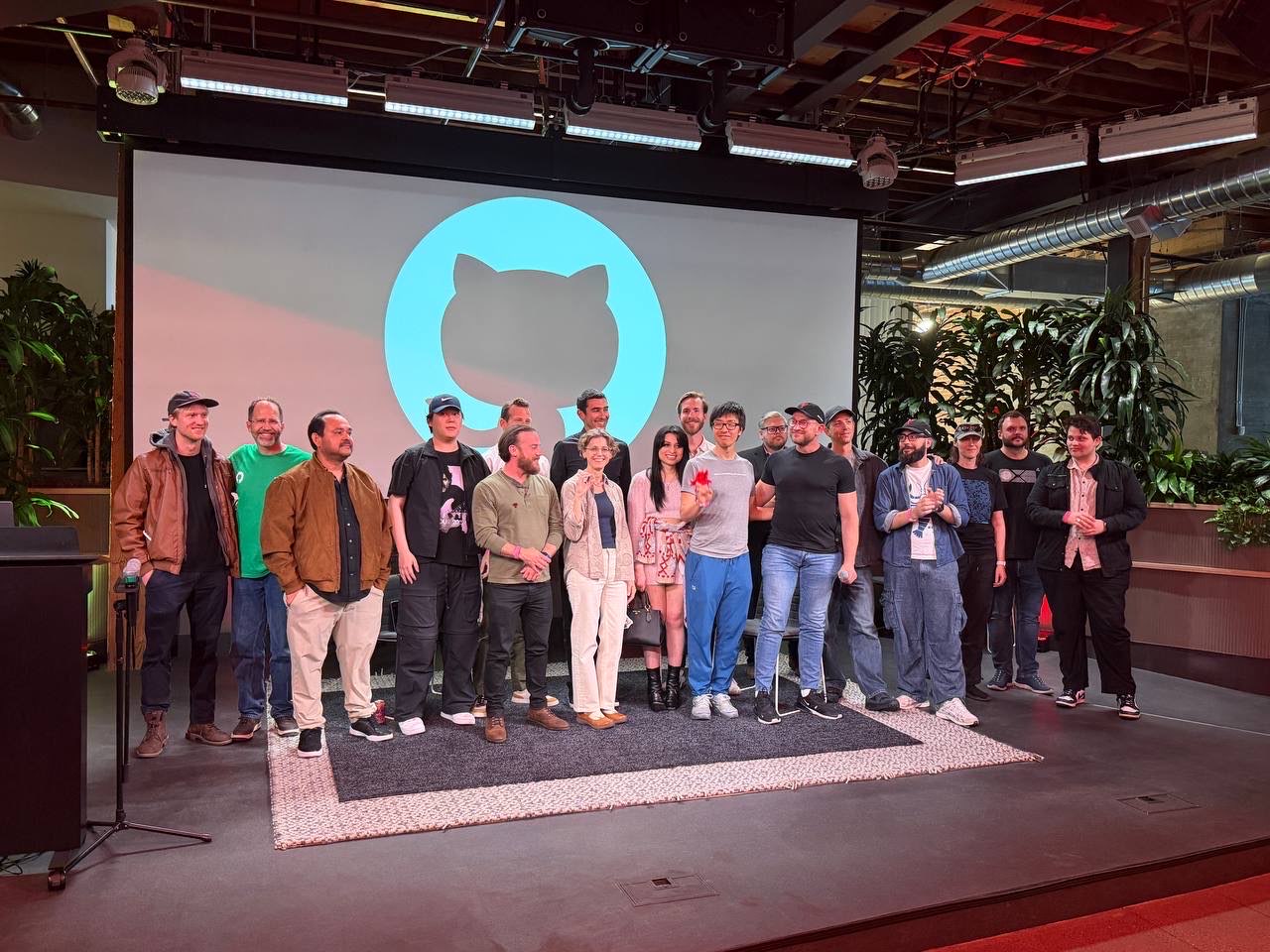 A crowd of attendees gathered together for a group photo in the event space.
